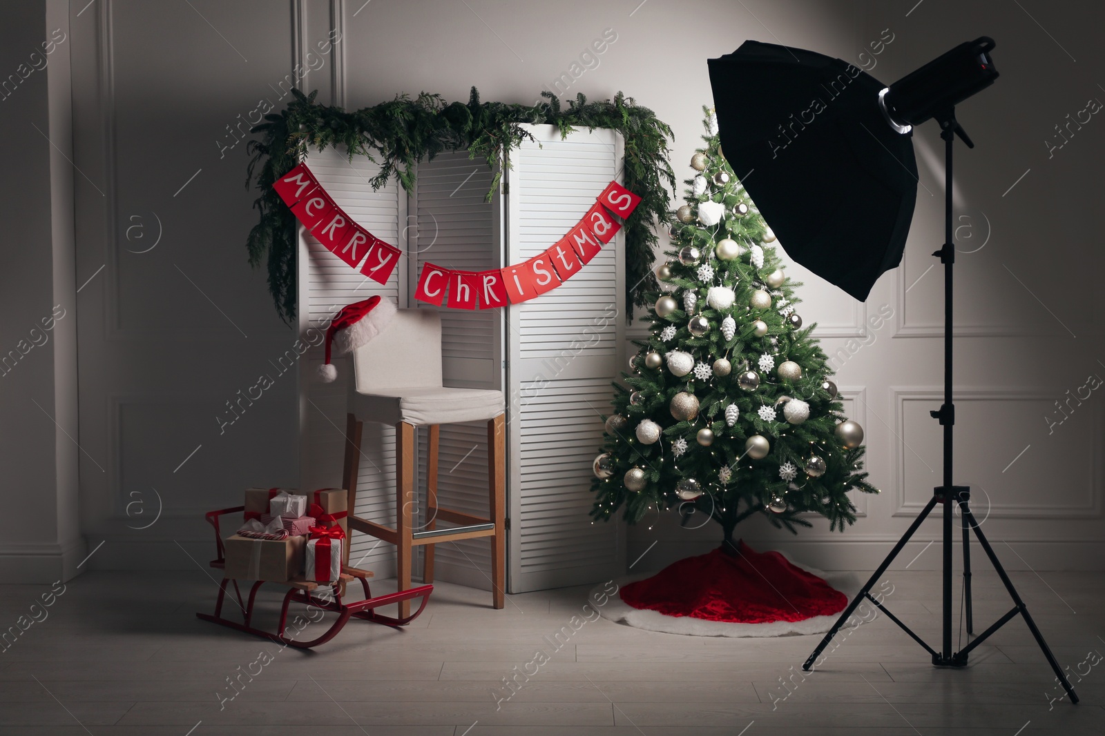 Photo of Beautiful photo zone with professional equipment and decorated Christmas tree