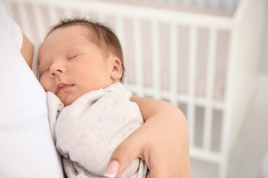 Young mother holding cute newborn baby, closeup