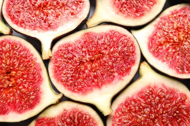 Cut ripe figs as background, top view