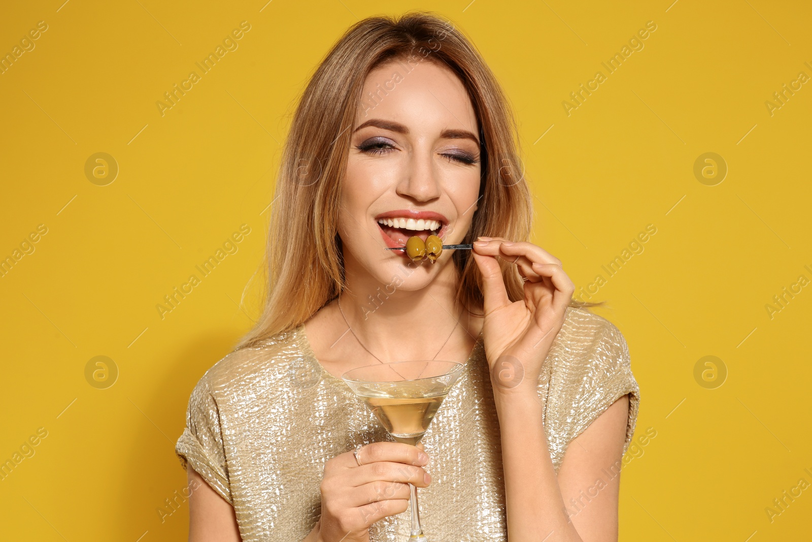 Photo of Beautiful young woman with glass of martini cocktail on color background