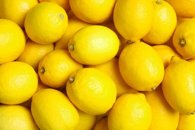 Photo of Many fresh ripe lemons as background, top view