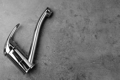 Photo of Single handle water tap on grey table, top view. Space for text