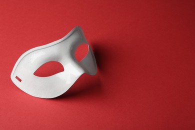 White theatre mask on red background, space for text