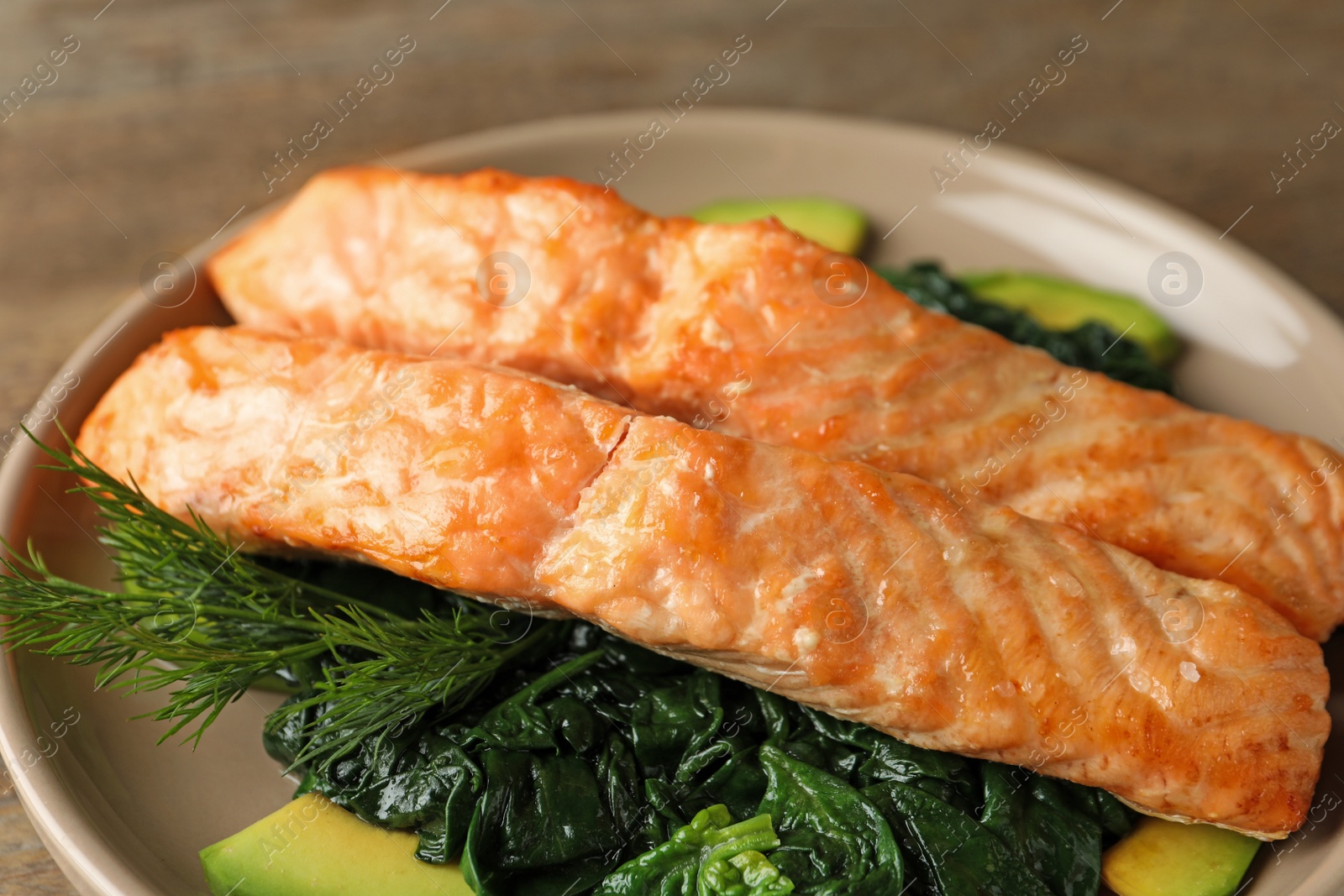 Photo of Tasty salmon with spinach and avocado on plate, closeup