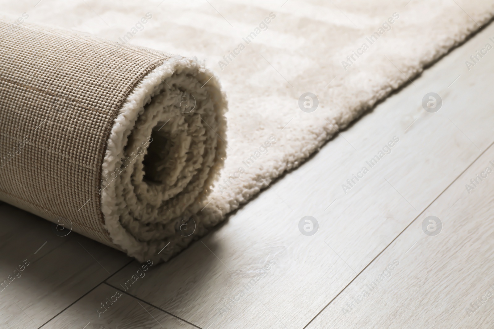 Photo of Rolled fuzzy carpet on wooden background. Space for text