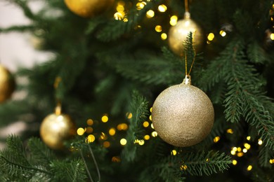 Photo of Beautiful Christmas balls hanging on fir tree, closeup