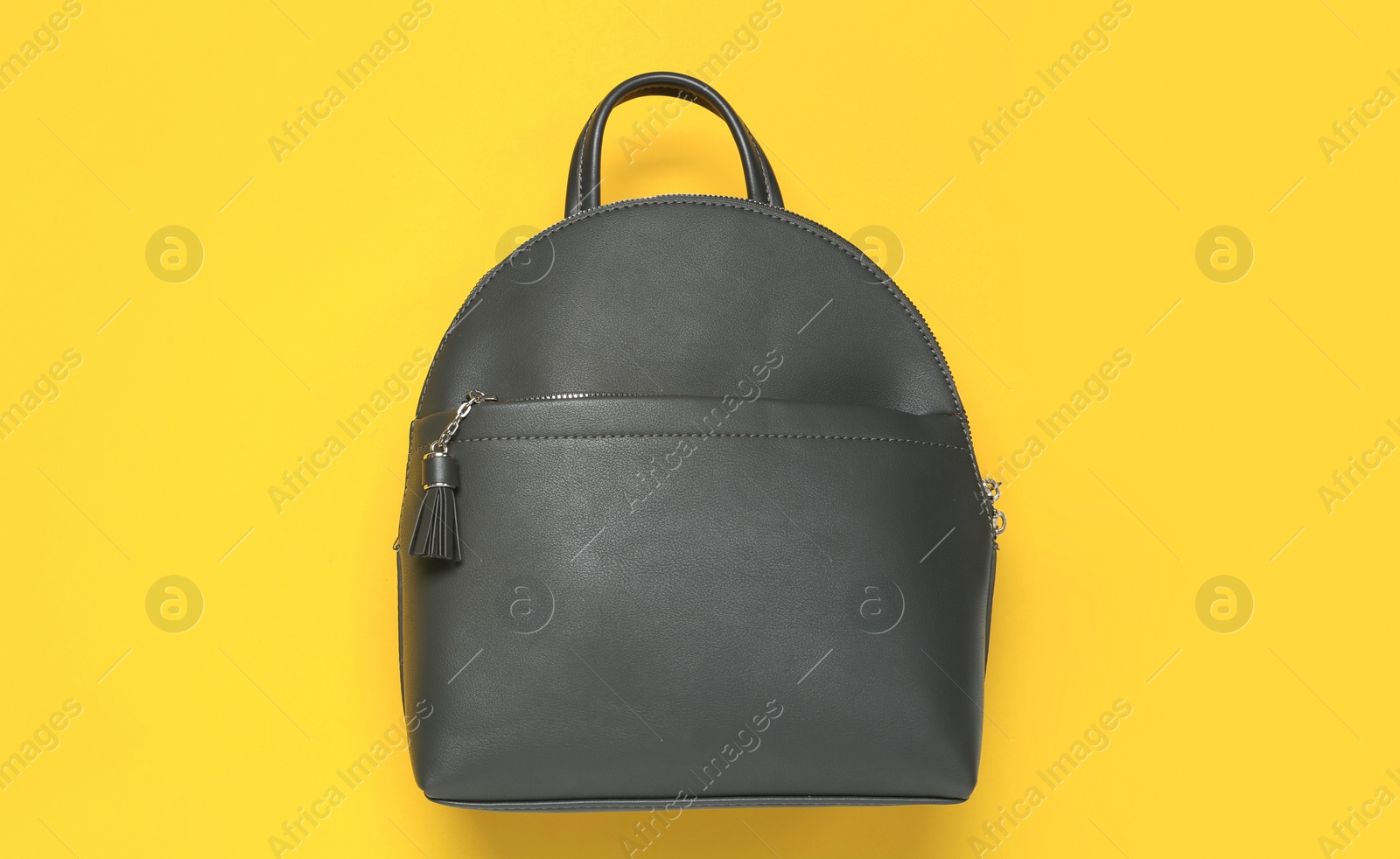 Photo of Stylish urban backpack on yellow background, top view