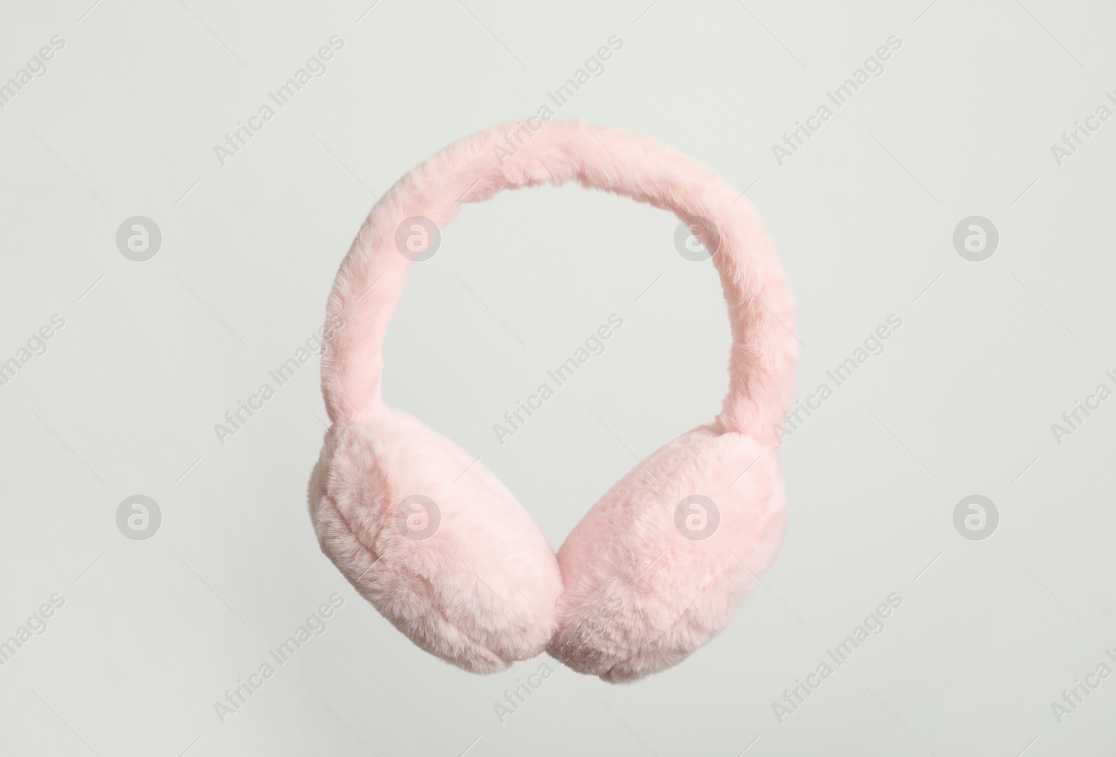 Photo of Fluffy earmuffs on white background. Stylish winter accessory