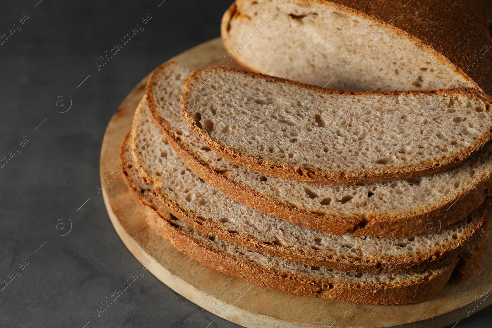 Photo of Freshly baked cut sourdough bread on grey table, closeup