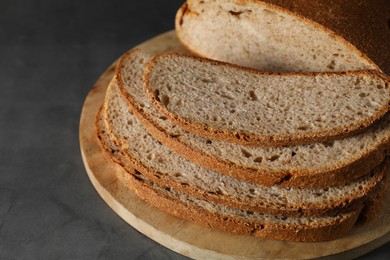 Photo of Freshly baked cut sourdough bread on grey table, closeup