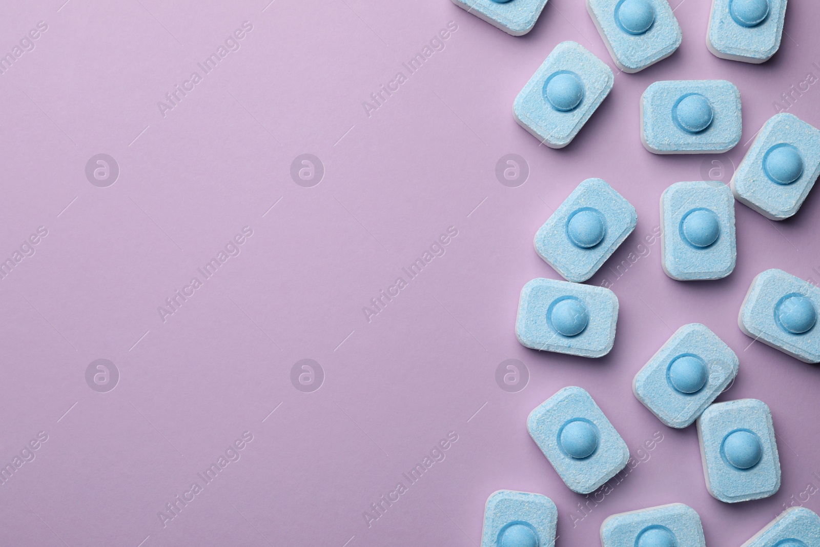 Photo of Water softener tablets on violet background, flat lay. Space for text
