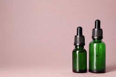 Cosmetic bottles of essential oils on color background. Space for text