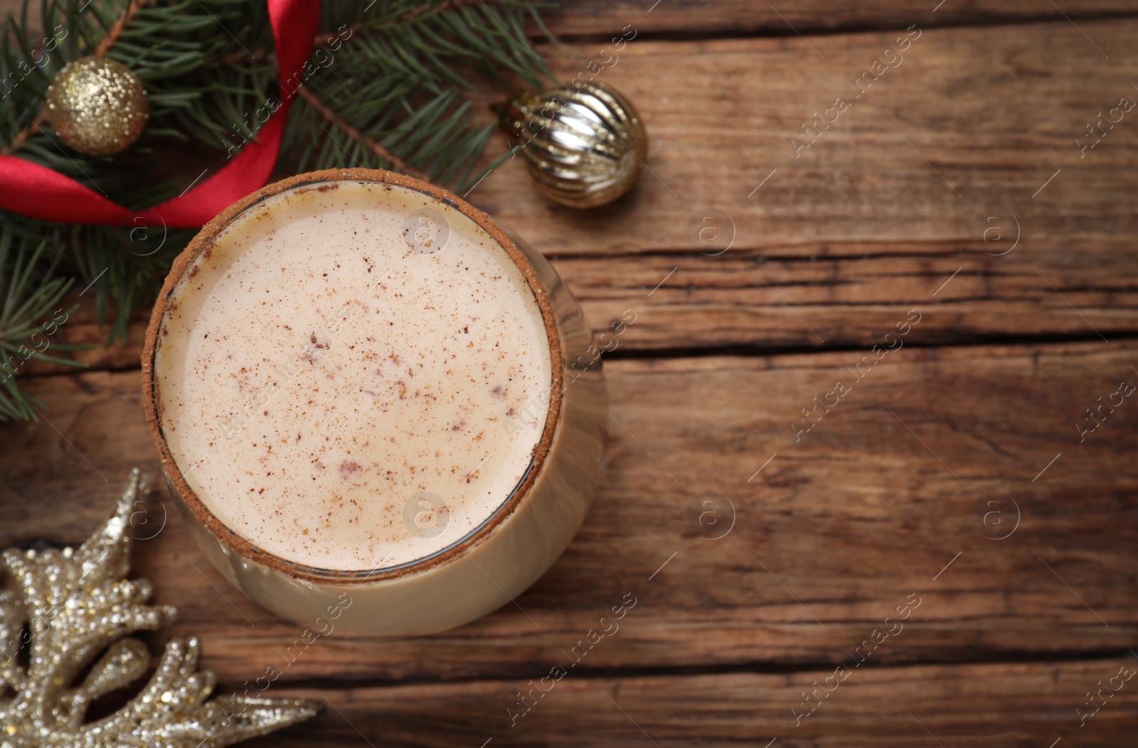 Photo of Delicious Christmas liqueur on wooden table, flat lay. Space for text