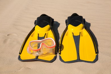 Photo of Pair of flippers and diving mask on sandy beach