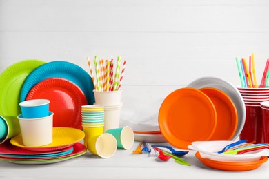 Set of disposable tableware on white wooden table