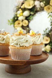 Tasty Easter cupcakes with vanilla cream on gray table