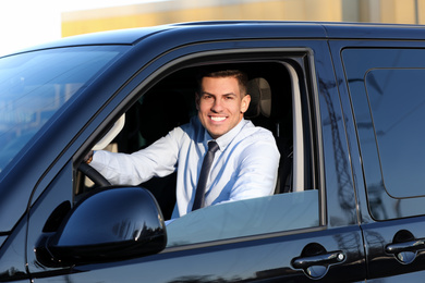 Photo of Man sitting in car outdoors. Buying new auto