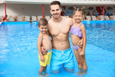 Young father with little children in swimming pool on sunny day