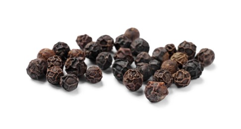 Photo of Aromatic spice. Many black dry peppercorns isolated on white