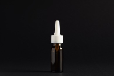 Bottle of nasal spray on black background