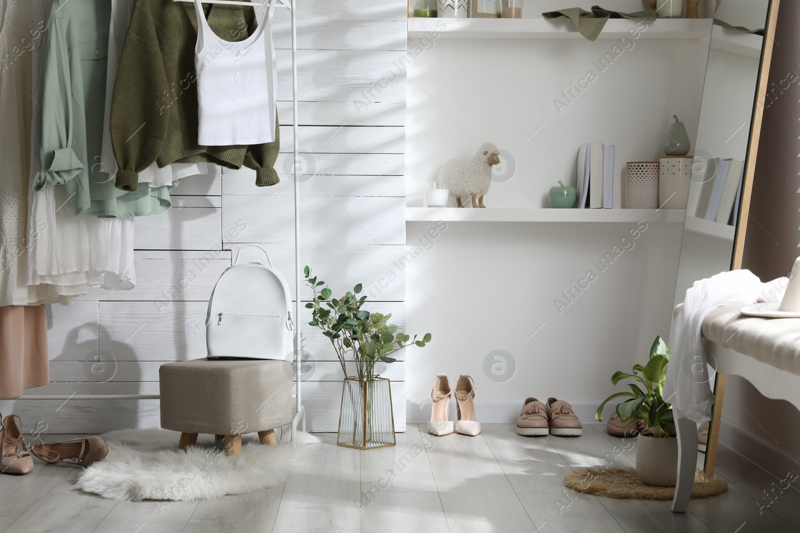 Photo of Rack with different stylish clothes, shoes and decorative elements in dressing room. Interior design