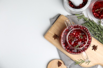 Photo of Tasty hot cranberry tea with rosemary and anise on white table, flat lay. Space for text