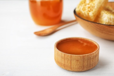 Photo of Bowl with sweet honey on table, closeup