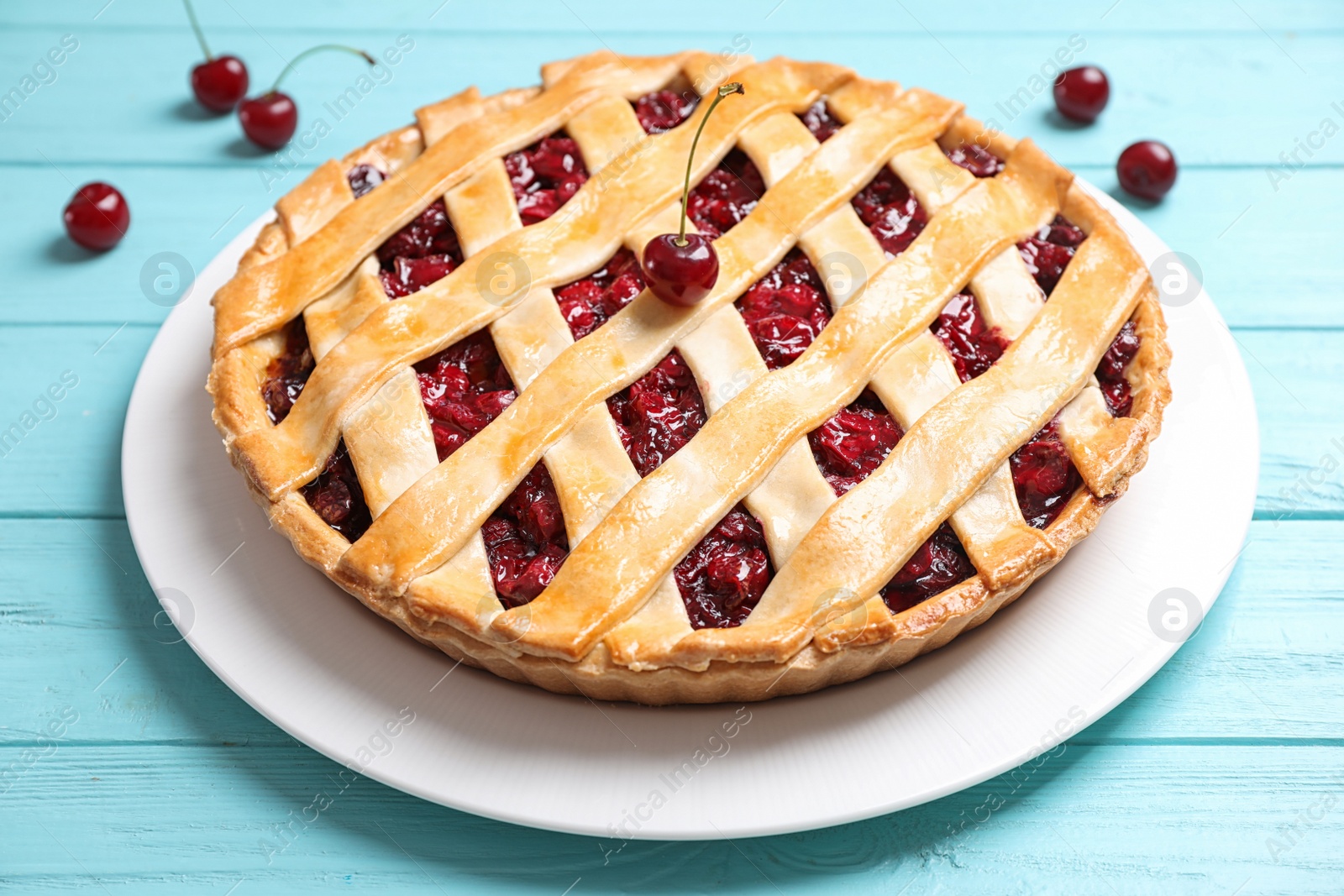 Photo of Delicious fresh cherry pie on light blue wooden table, closeup