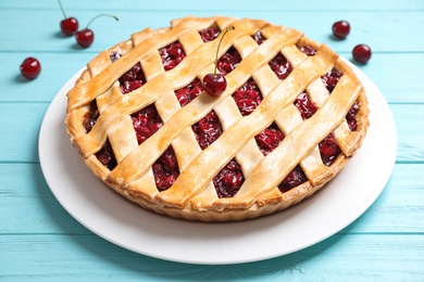 Delicious fresh cherry pie on light blue wooden table, closeup