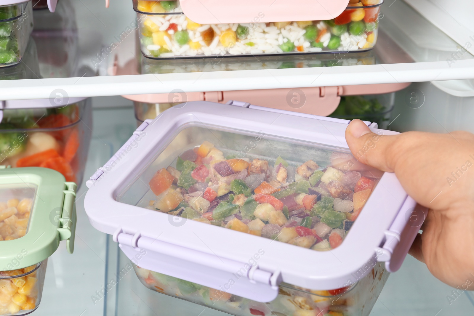 Photo of Woman taking box with vegetable mix from refrigerator, closeup