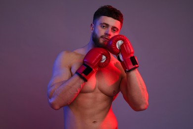 Man in boxing gloves on color background