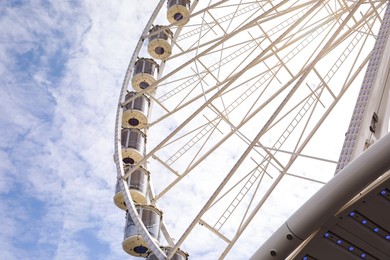 Beautiful Ferris wheel against cloudy sky, low angle view