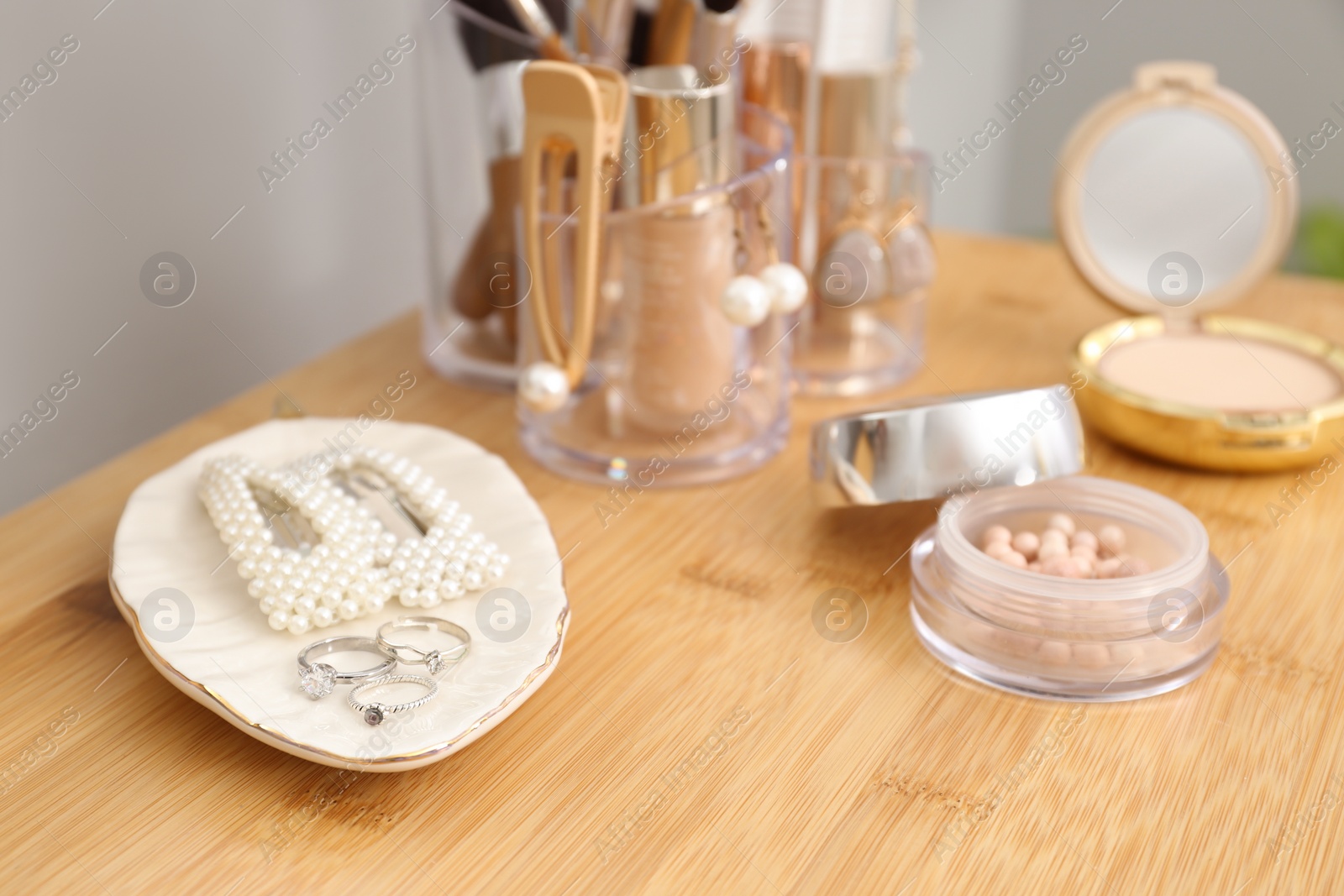 Photo of Makeup cosmetics and woman's accessories on wooden dressing table