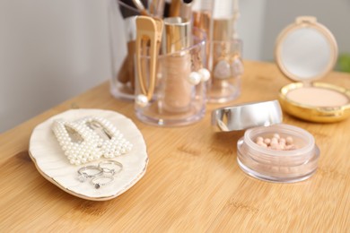 Makeup cosmetics and woman's accessories on wooden dressing table