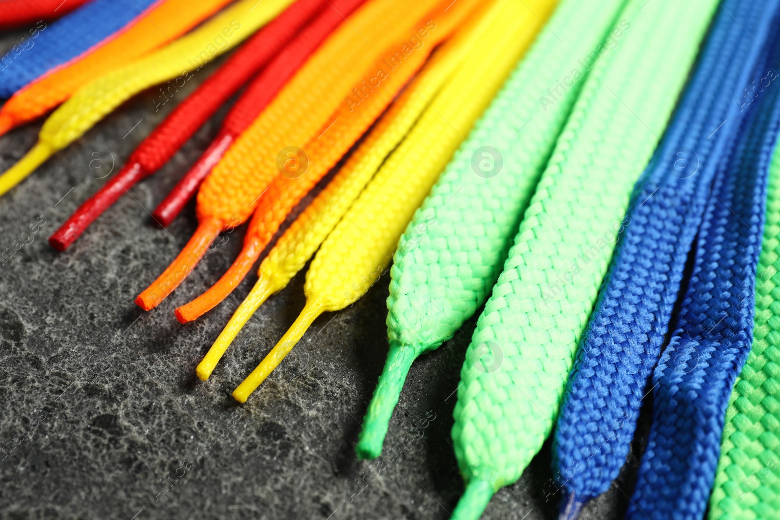 Photo of Colorful shoelaces on grey background, closeup. Stylish accessory