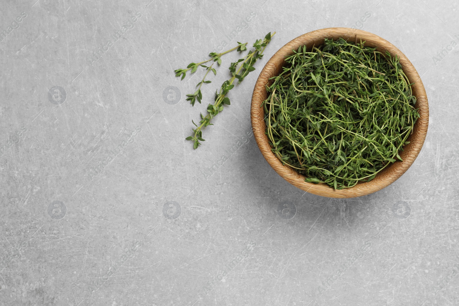Photo of Aromatic thyme on light grey table, flat lay. Space for text
