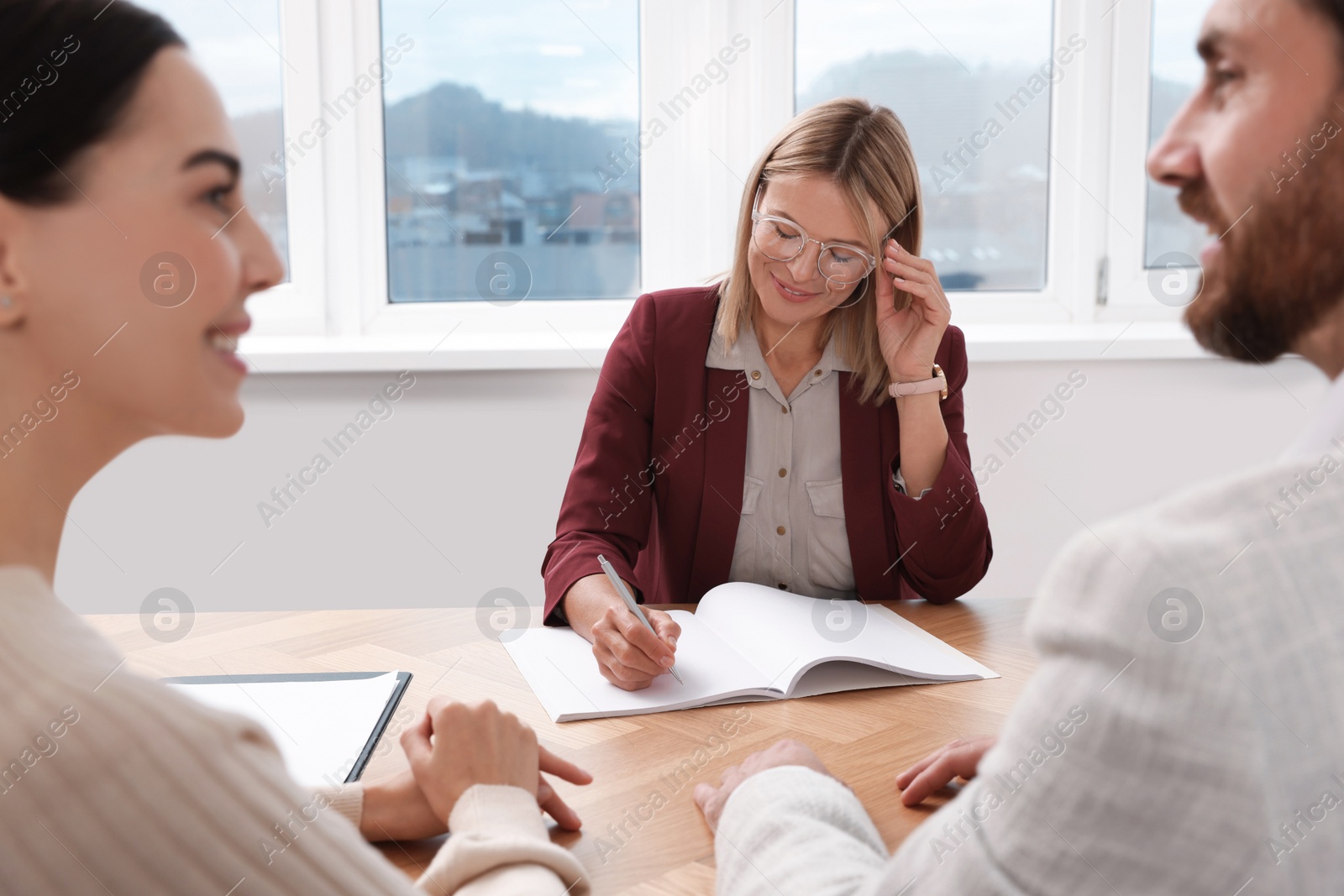 Photo of Real estate agent working with couple in new apartment