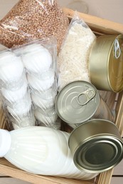 Photo of Donation box with food products on table, top view