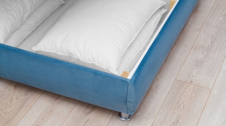 Photo of Storage drawer under bed with white pillows indoors, above view