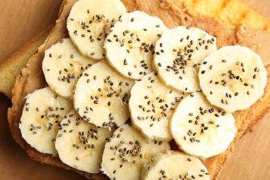 Tasty toast with banana, peanut butter and chia seeds, closeup