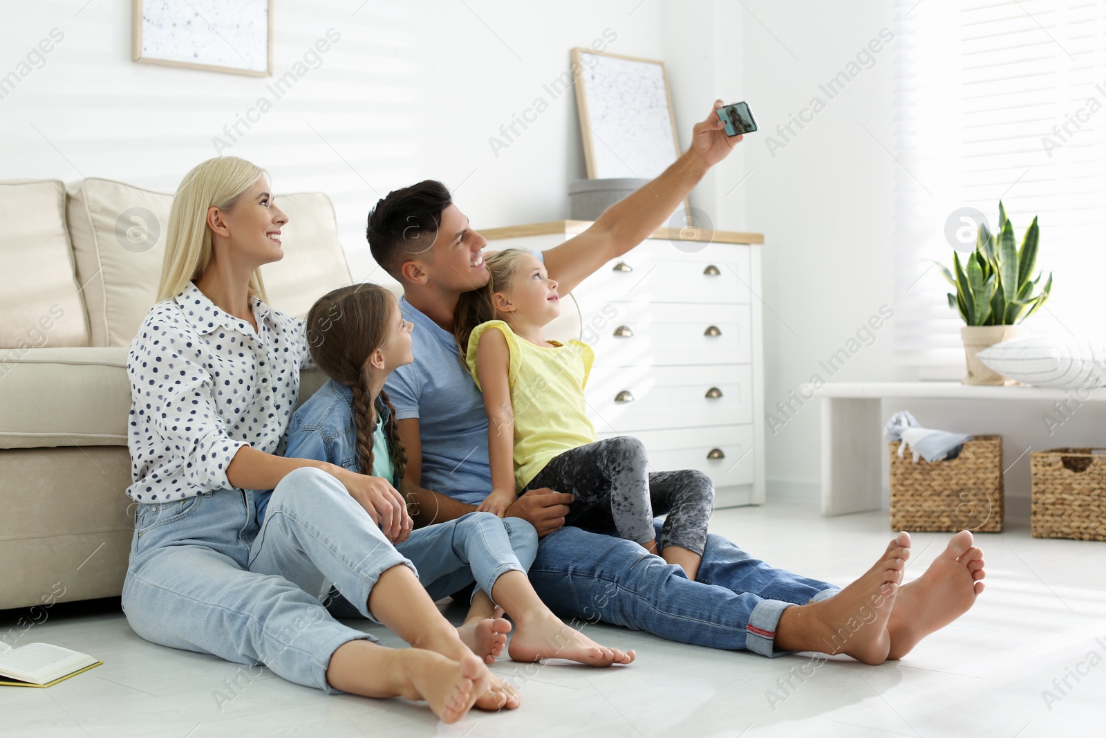 Photo of Happy family taking selfie on floor at home