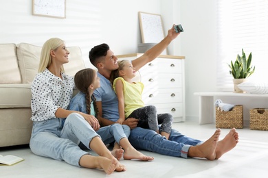 Happy family taking selfie on floor at home