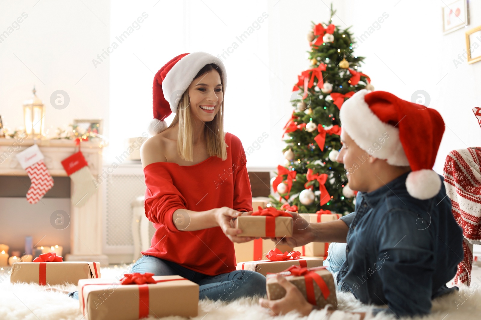 Photo of Young couple with Christmas gifts at home