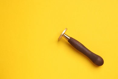 Photo of One stamp tool on yellow background, top view. Space for text