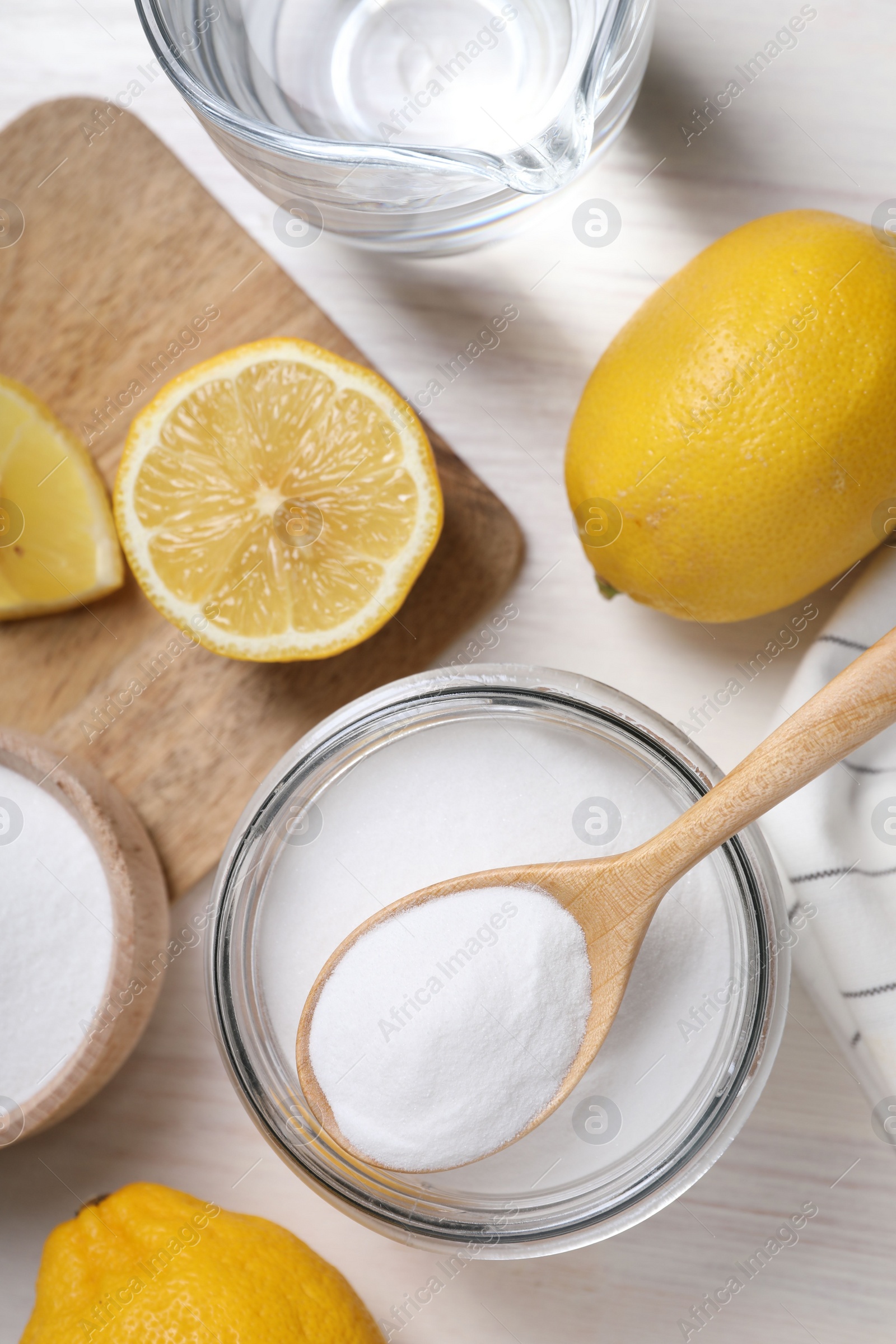 Photo of Baking soda, vinegar and lemons on white wooden table, flat lay