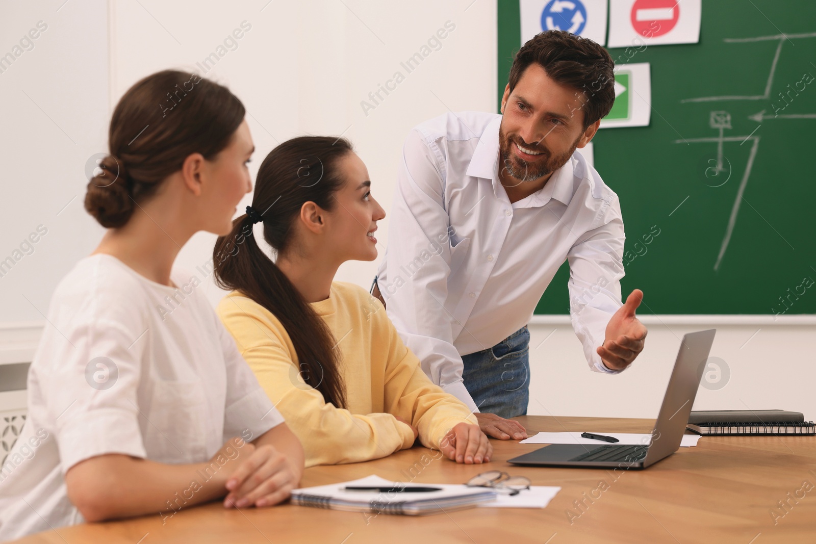 Photo of Happy teacher giving lesson in driving school