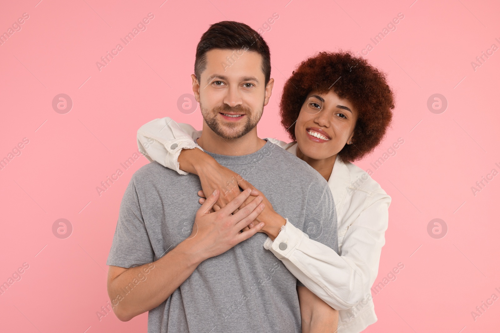 Photo of International dating. Happy couple hugging on pink background