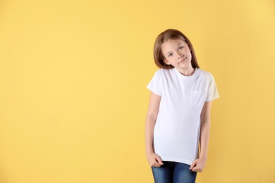 Photo of Little girl in t-shirt on color background. Mockup for design