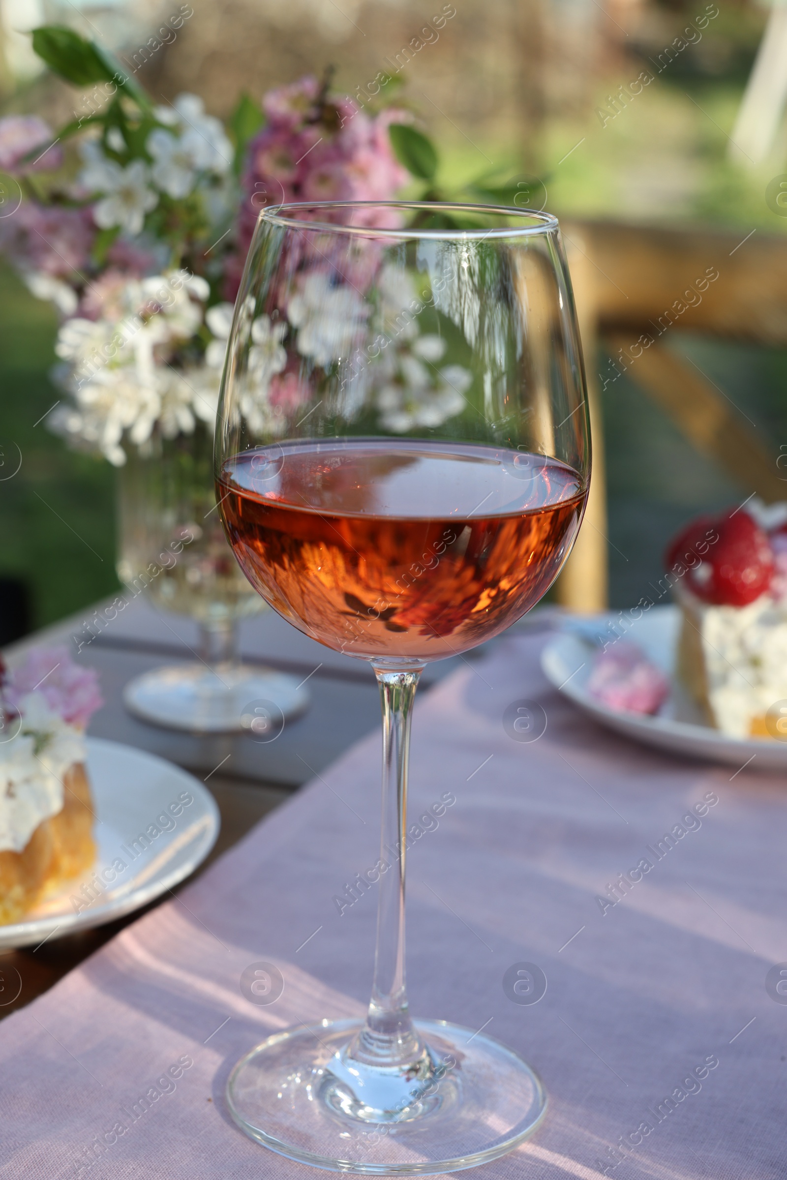 Photo of Glass of wine on table served for romantic date in garden