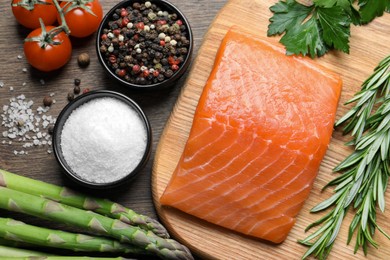 Photo of Fresh raw salmon and ingredients for marinade on wooden table, flat lay
